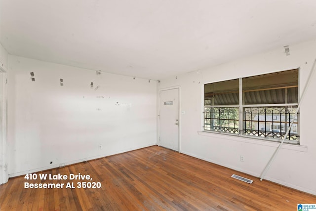 spare room featuring baseboards, visible vents, and hardwood / wood-style flooring