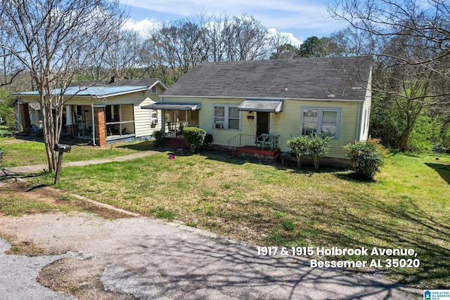 view of front facade with a front lawn and a shingled roof