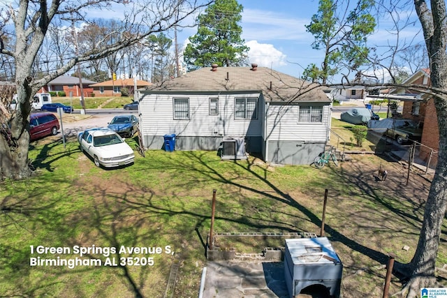 back of property with a lawn, a shingled roof, and cooling unit