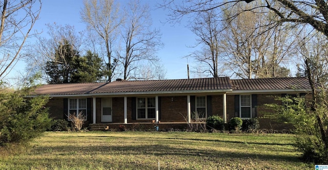 single story home with metal roof, covered porch, and a front yard