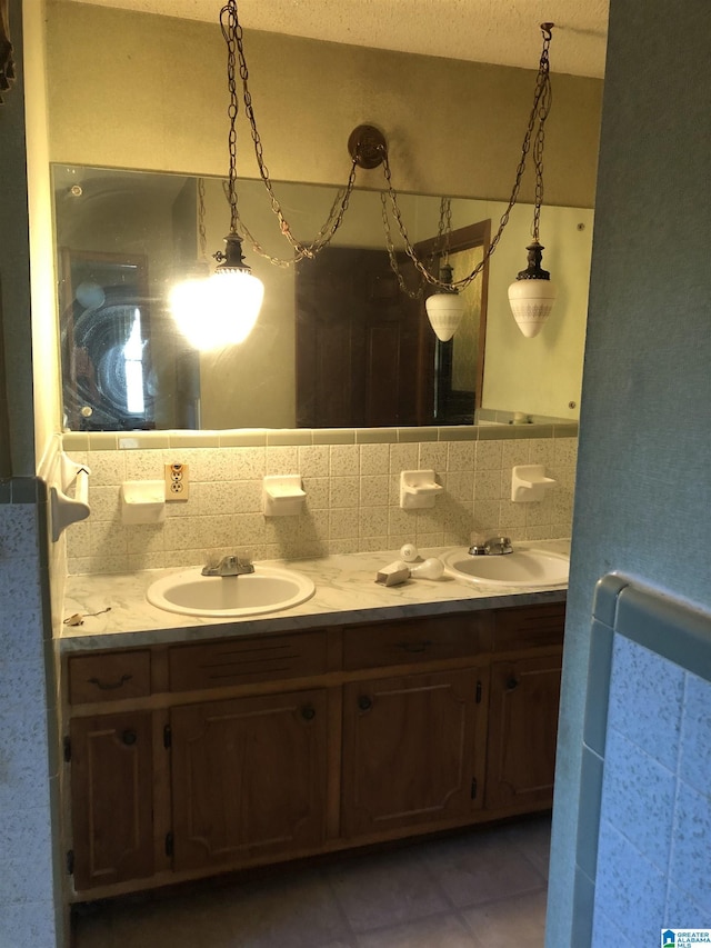 full bathroom featuring double vanity, decorative backsplash, a sink, and tile patterned floors