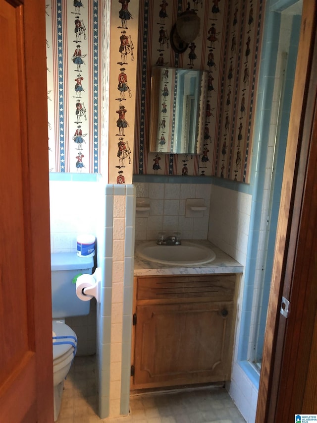 bathroom featuring toilet, decorative backsplash, and vanity