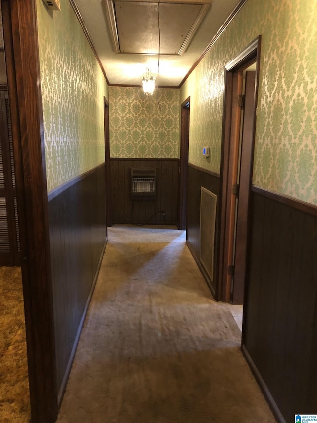 hallway featuring attic access, wainscoting, and wallpapered walls