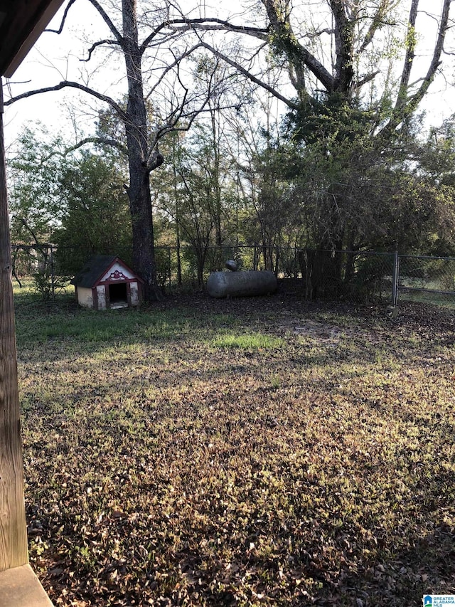 view of yard with an outbuilding, fence, and a shed