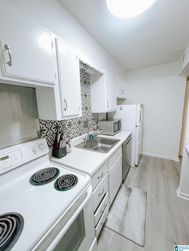 kitchen with light countertops, a sink, dishwasher, electric stove, and white cabinets