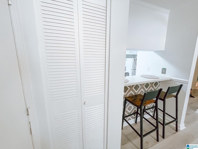 hallway featuring crown molding and baseboards