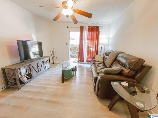 living room with crown molding, a ceiling fan, wood finished floors, a textured ceiling, and baseboards