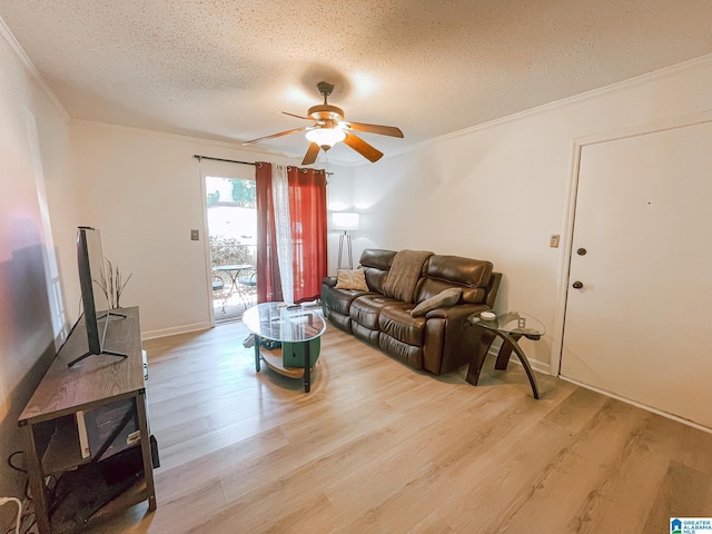 living area with a textured ceiling, crown molding, wood finished floors, and a ceiling fan