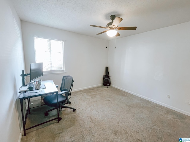 carpeted office space with a textured ceiling, baseboards, and ceiling fan