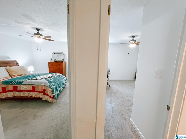 bedroom with carpet, baseboards, ceiling fan, and a textured ceiling