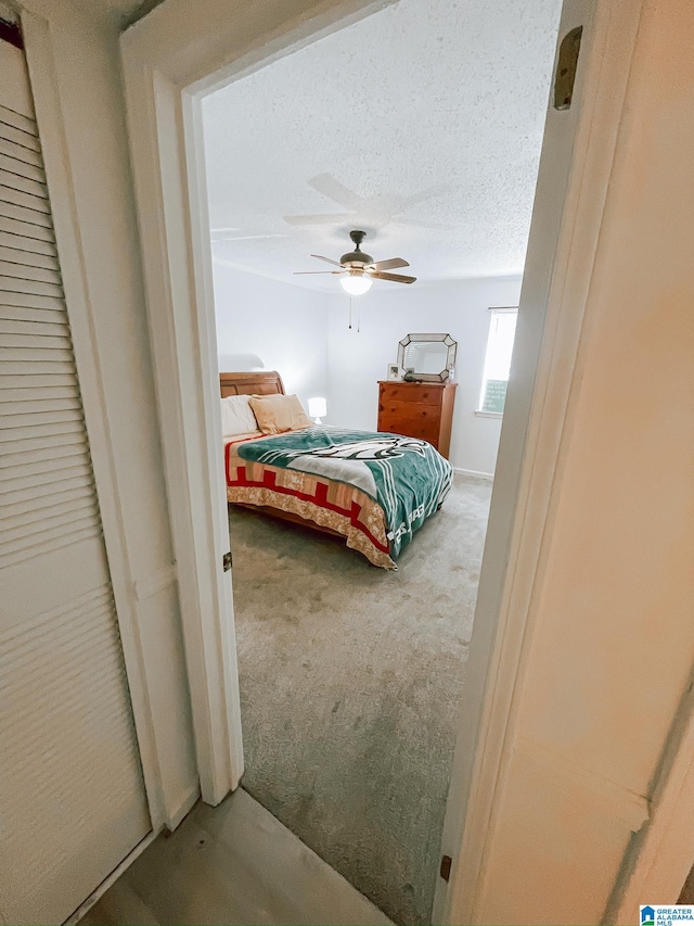 bedroom featuring a ceiling fan, carpet, and a textured ceiling