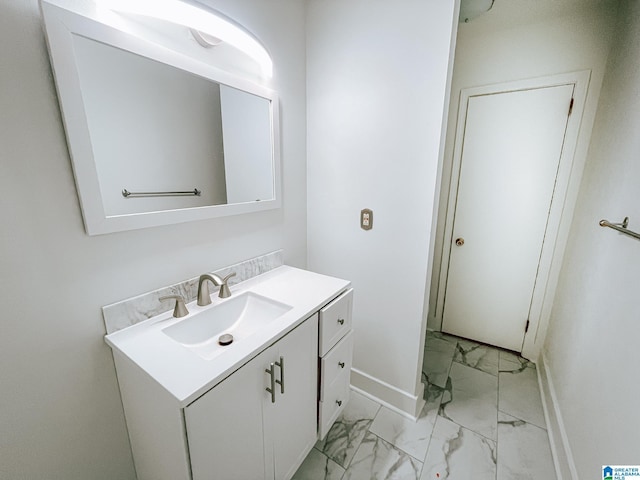 bathroom featuring marble finish floor, baseboards, and vanity