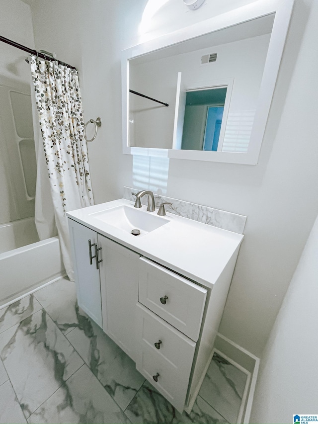 bathroom featuring marble finish floor, vanity, shower / tub combo with curtain, and visible vents