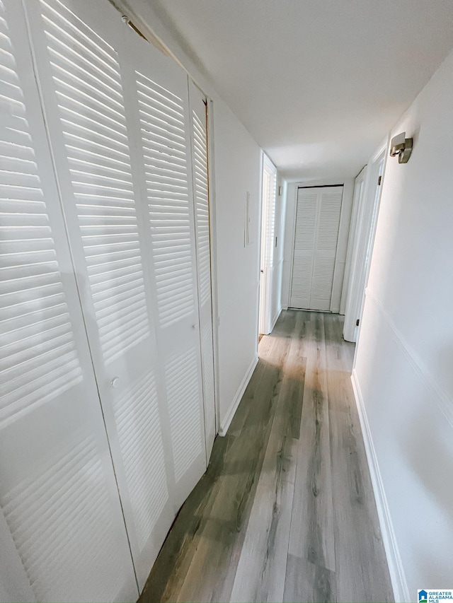hall featuring baseboards and wood finished floors