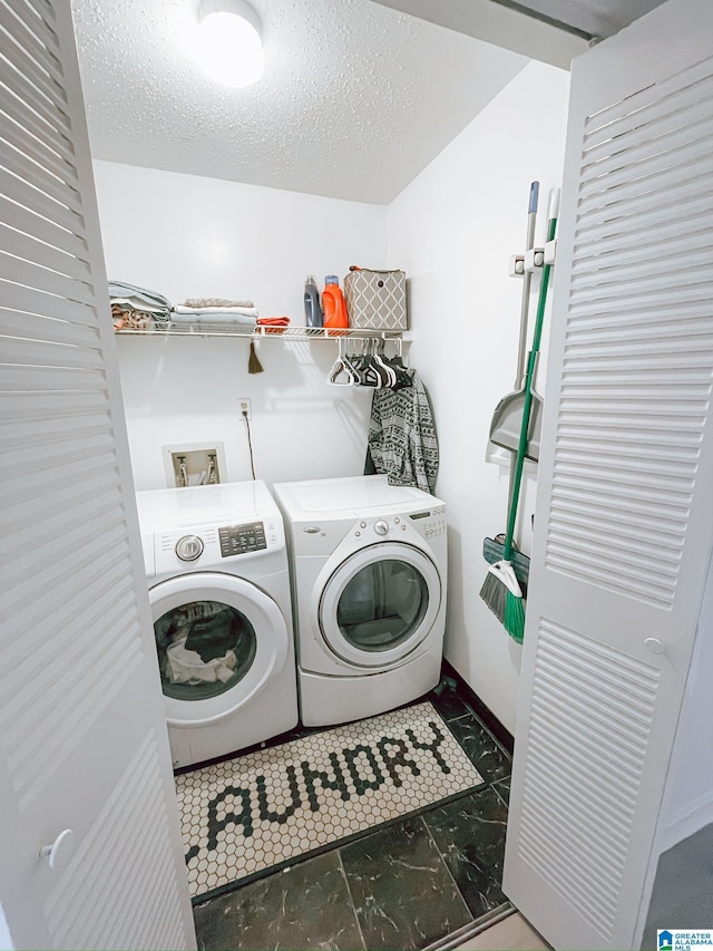 laundry area with marble finish floor, a textured ceiling, laundry area, and washer and clothes dryer