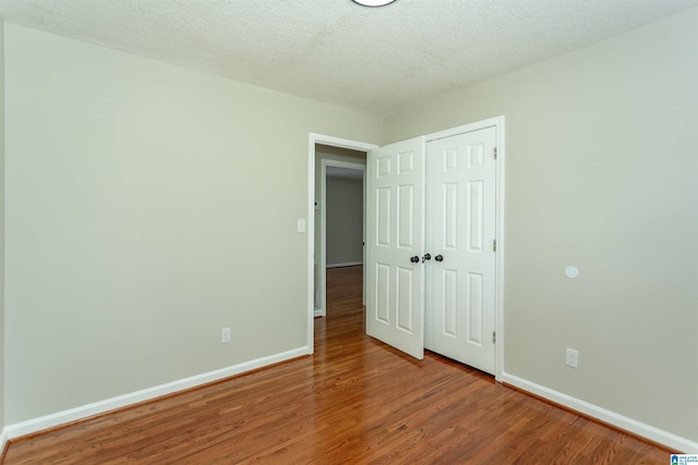 5400 Etta Dr, Mount Olive, AL 35117 - unfurnished bedroom featuring baseboards, a textured ceiling, wood finished floors, and a closet