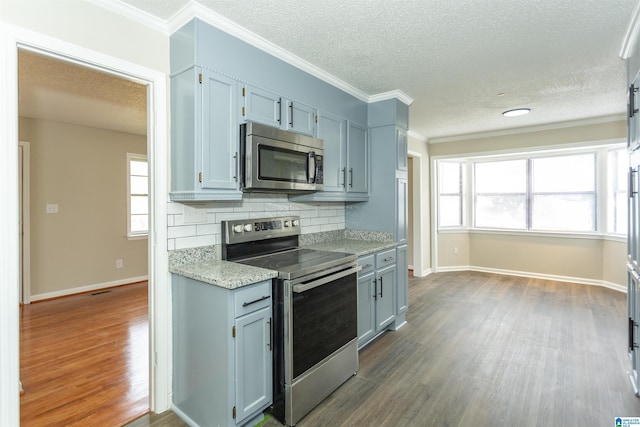 5400 Etta Dr, Mount Olive, AL 35117 - kitchen featuring crown molding, dark wood-style flooring, stainless steel appliances, baseboards, and decorative backsplash