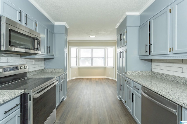 5400 Etta Dr, Mount Olive, AL 35117 - kitchen featuring dark wood-type flooring, light stone countertops, ornamental molding, and stainless steel appliances