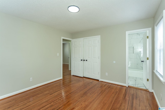 5400 Etta Dr, Mount Olive, AL 35117 - unfurnished bedroom with a closet, ensuite bath, baseboards, and wood finished floors