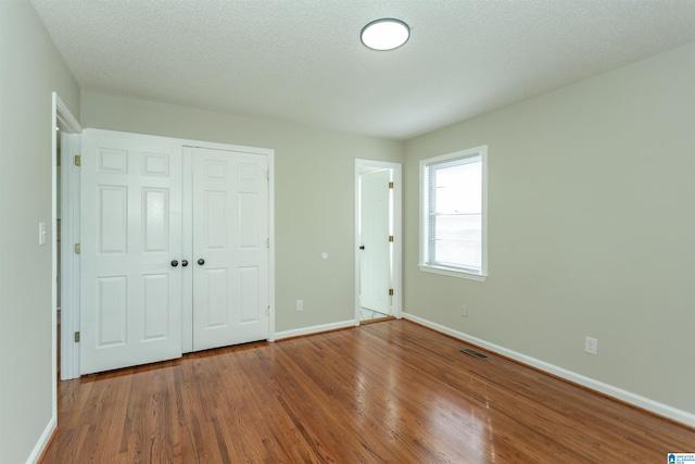 5400 Etta Dr, Mount Olive, AL 35117 - unfurnished bedroom featuring visible vents, a closet, baseboards, and wood finished floors