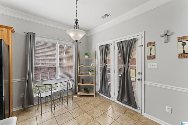 dining room featuring light tile patterned floors, visible vents, baseboards, and ornamental molding