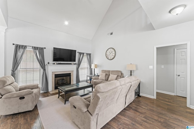 living area with high vaulted ceiling, a fireplace, visible vents, baseboards, and dark wood-style floors