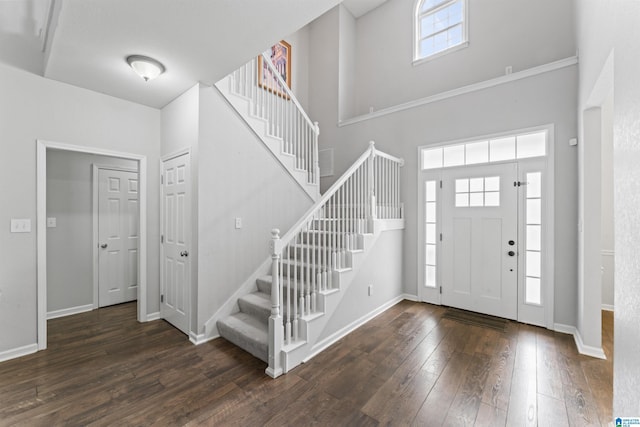 entrance foyer featuring wood-type flooring, baseboards, a high ceiling, and stairs