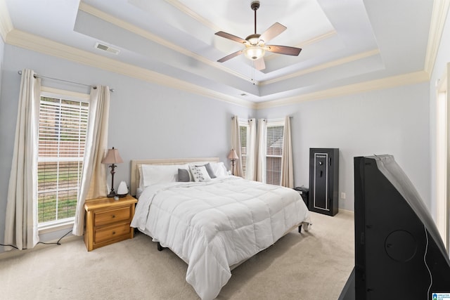 bedroom featuring light carpet, a raised ceiling, crown molding, visible vents, and ceiling fan