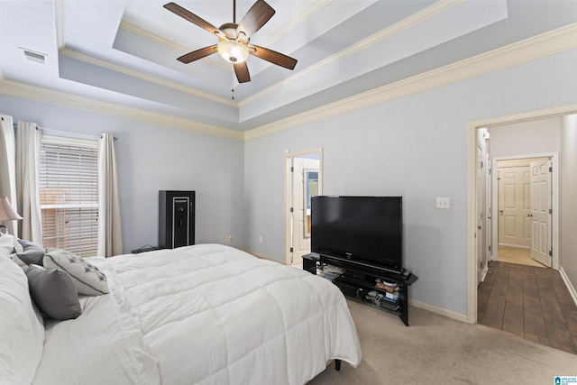 carpeted bedroom with baseboards, ornamental molding, a raised ceiling, visible vents, and ceiling fan