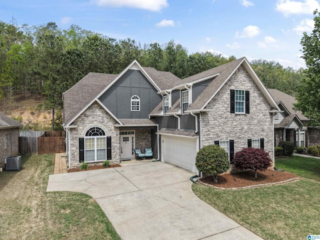 view of front of home with roof with shingles, stone siding, an attached garage, driveway, and central AC unit