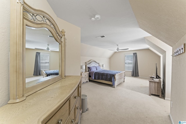 bedroom featuring visible vents, baseboards, ceiling fan, vaulted ceiling, and light carpet
