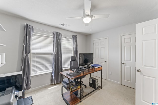 office area with visible vents, ceiling fan, light carpet, and baseboards