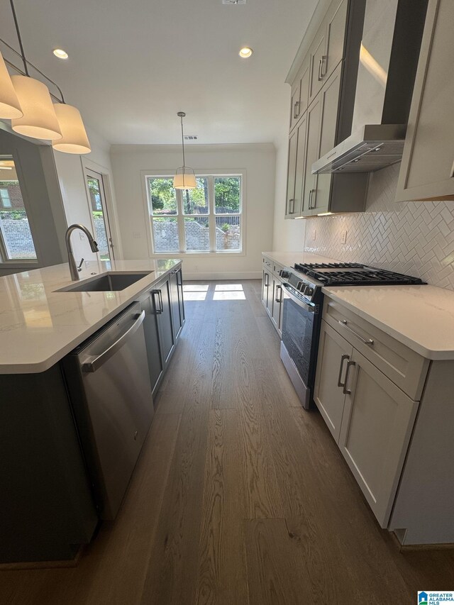 104 Linden Ln, Birmingham, AL 35242 - kitchen featuring wall chimney range hood, appliances with stainless steel finishes, dark wood-type flooring, decorative backsplash, and a kitchen island with sink