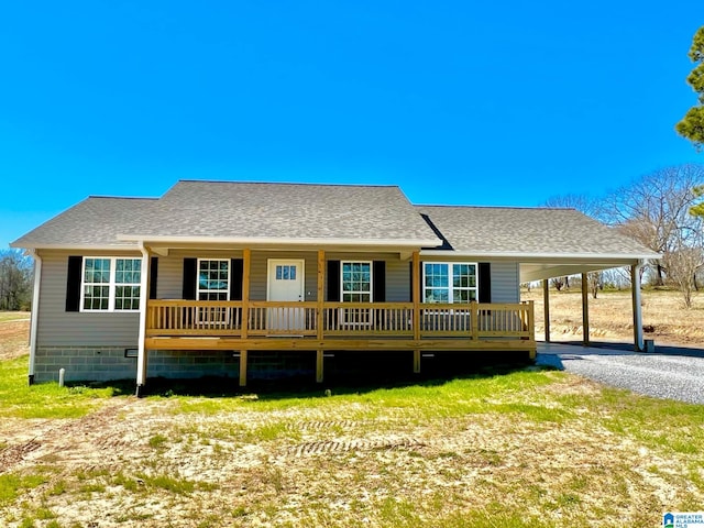 view of front facade with an attached carport, a shingled roof, covered porch, and driveway
