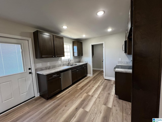 kitchen with light countertops, light wood-type flooring, stainless steel appliances, a sink, and dark brown cabinets