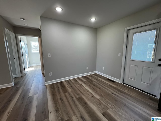 entryway with dark wood-type flooring, baseboards, and recessed lighting