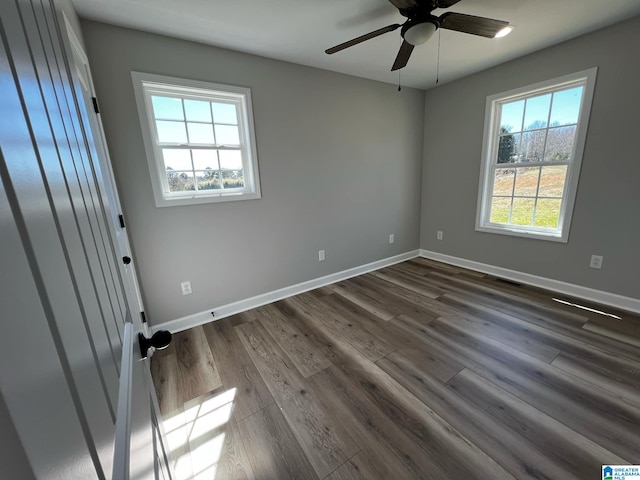 spare room with dark wood-type flooring, baseboards, and ceiling fan