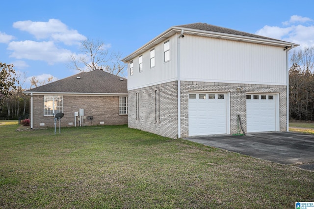 view of side of property with brick siding, a lawn, driveway, and an attached garage
