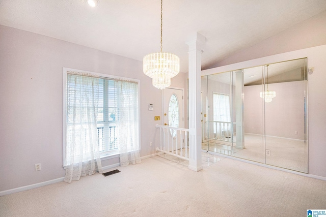 interior space with carpet floors, vaulted ceiling, multiple windows, and a chandelier