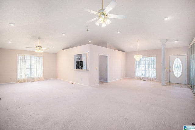 unfurnished living room featuring light carpet, a wealth of natural light, ornate columns, and a ceiling fan