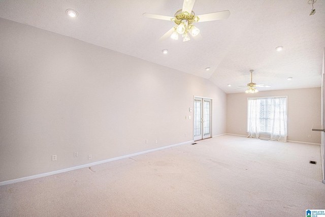 spare room featuring light carpet, baseboards, lofted ceiling, and ceiling fan