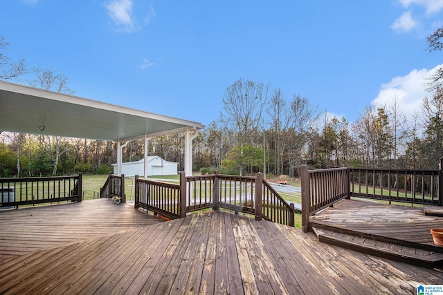 wooden deck featuring an outdoor structure and a yard