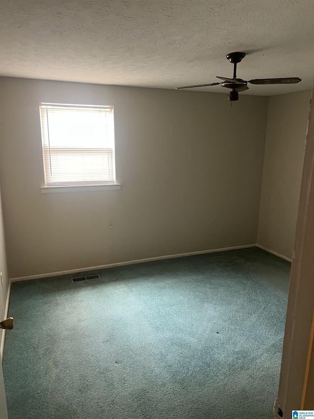 carpeted spare room with a textured ceiling, baseboards, ceiling fan, and visible vents