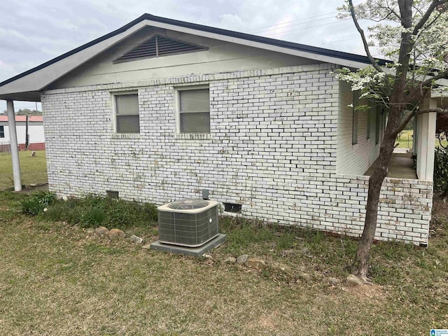 view of home's exterior featuring brick siding, central AC, and a lawn