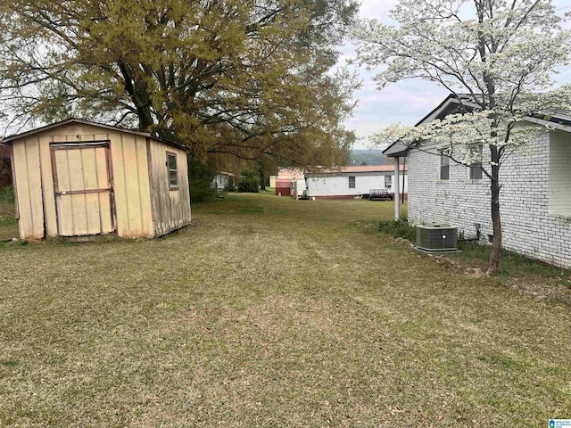 view of yard featuring central AC unit, an outdoor structure, and a shed