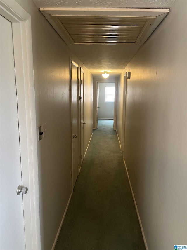 corridor featuring baseboards, visible vents, and carpet