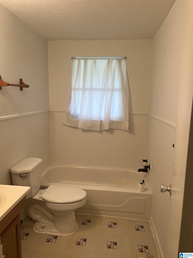 bathroom featuring toilet, vanity, a washtub, and a textured ceiling