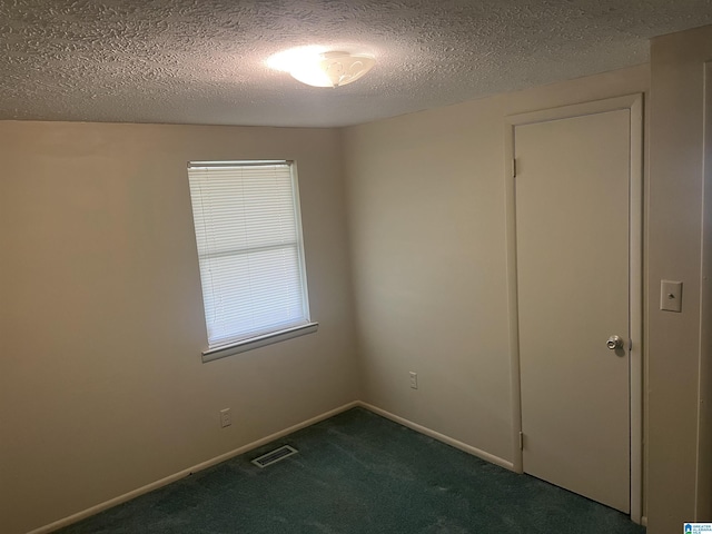 carpeted empty room with a textured ceiling, baseboards, and visible vents