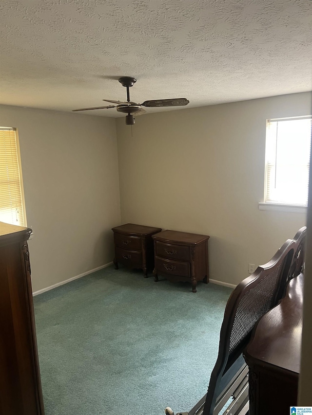unfurnished bedroom with a ceiling fan, carpet floors, baseboards, and a textured ceiling