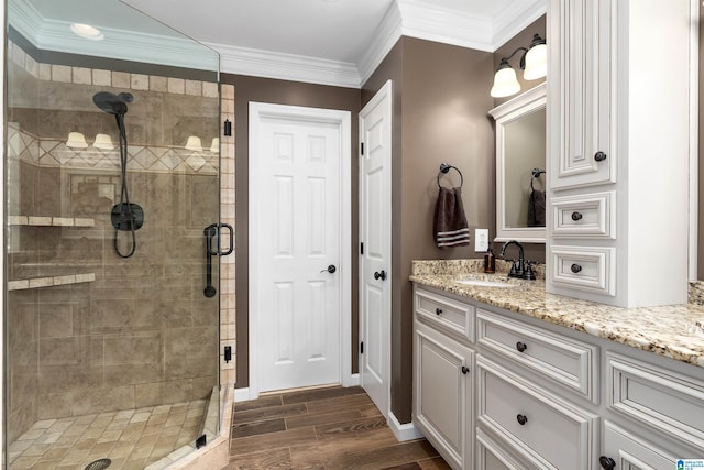 full bathroom featuring a shower stall, vanity, ornamental molding, and wood tiled floor
